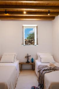 2 Betten in einem Zimmer mit Fenster in der Unterkunft Sifnos Themonies in Apollonia