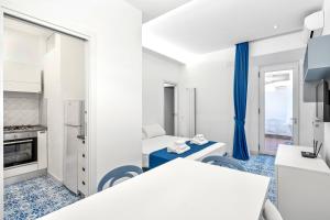 eine Küche mit weißen Wänden und blauem Boden in der Unterkunft LUXE Minimal Retreat, Amalfi Coast - AirHome in Vico Equense