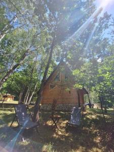 2 Stühle und eine Blockhütte im Wald in der Unterkunft Forest Rhapsody Brezna in Plužine
