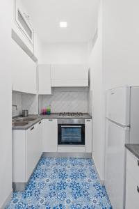 eine Küche mit weißen Schränken und blauem Fliesenboden in der Unterkunft LUXE Minimal Retreat, Amalfi Coast - AirHome in Vico Equense