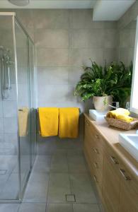 uma casa de banho com chuveiro e toalhas amarelas em Kennedy House Euroa A delightful place to stay em Euroa