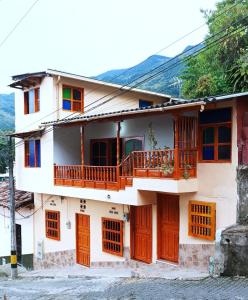 ein Haus mit Holztüren und einem Balkon in der Unterkunft Petroglifo Room Támesis in Támesis