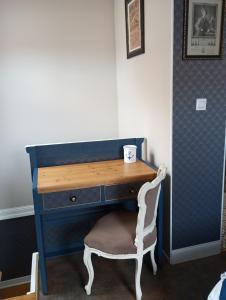 a blue desk with a chair and a cup on it at Chambre avec salle d'eau privative in Dunkerque