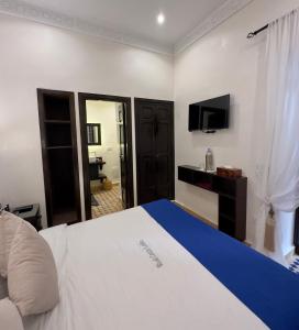 マラケシュにあるリアド カサ ララのベッドとテレビが備わるホテルルームです。