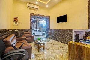 a living room with a couch and a tv on a wall at Townhouse Centre Point Inn Near Esplanade Metro Station in Kolkata