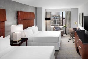 ニューヨークにあるウェスティン ニューヨーク グランドセントラルのベッド2台とテレビが備わるホテルルームです。