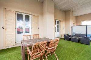 a room with a table and chairs and a screen at Flat with terrace near Disneyland Paris - Welkeys in Bailly-Romainvilliers
