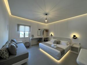 a bedroom with two beds and a couch in it at Kamara Sea View Junior Suite in Kamari