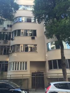 un edificio de apartamentos con coches estacionados frente a él en LADO DO METRÔ COPA 4 quartos, en Río de Janeiro