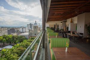 a balcony with tables and chairs and a view of a city at Hotel Soratama in Pereira
