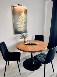 uma mesa de jantar com duas cadeiras e uma planta em Apartament Liść em Tarnobrzeg