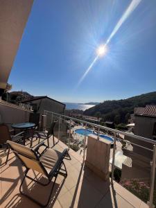 a balcony with chairs and a view of a pool at Charming apartment near beach in Sveti Stefan