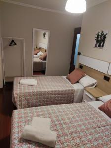 a hotel room with two beds and a mirror at Casa andaina in Palas de Rei