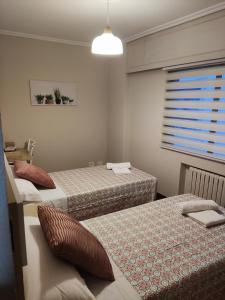 帕拉斯德雷的住宿－Casa andaina，一间卧室设有两张床和一个带百叶窗的窗户。