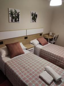 帕拉斯德雷的住宿－Casa andaina，酒店客房设有两张床和一张桌子。