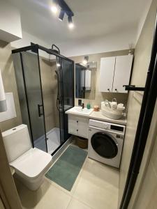 een badkamer met een douche en een wasmachine bij HB Cozy Home - Przytulne Mieszkanie 