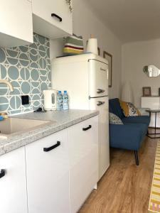 een keuken met witte kasten en een blauwe bank bij HB Cozy Home - Przytulne Mieszkanie 