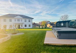 Un patio trasero con piscina y una casa. en Tirolian Lodge North, Whirlpool, Sauna, Lagerfeuer, en Bundorf 8 fotos más