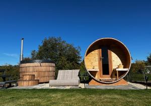 a circular house with a chair and a mirror at Tirolian Lodge North, Whirlpool, Sauna, Lagerfeuer in Bundorf