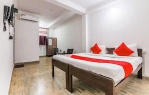 a bedroom with a large bed with red pillows at OYO Flagship 81063 Milton Inn in Baga