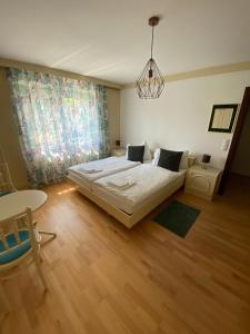 a bedroom with a large bed and a table at Gemütliches Haus in Seewalchen am Attersee in Seewalchen