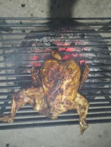 a chicken cooking on a grill in an oven at Atithi Griha Homestay - ARITAR, SILK ROUTE, SIKKIM in Aritar