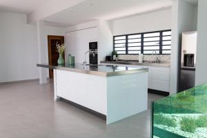 a kitchen with white cabinets and a counter top at Charming Villa With Breathtaking View Over The Spanish Water in Willemstad