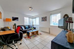 a living room with a couch and a tv at Kings Lodge One Bed Apartment in Belfast
