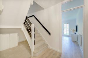 a white staircase in a white room with a window at Private house seconds from Portobello Road in London