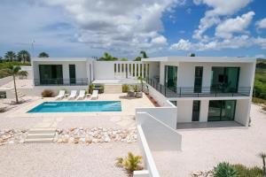 a house on the beach with a swimming pool at Charming Villa With Breathtaking View Over The Spanish Water in Willemstad