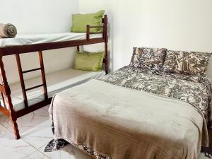 1 Schlafzimmer mit 2 Etagenbetten und 1 Bett in der Unterkunft Recanto Monte Trigo in São Francisco do Sul