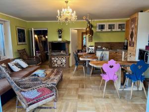 ein Wohnzimmer mit Sofa, Tisch und Stühlen in der Unterkunft Glückliche Kuh-Villa - Achtsamer Rückzugsort mit Traumgarten, Schwimmteich & Raum zum Sein bis 18 Personen - Allgäu in Kempten