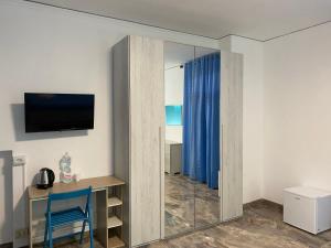 a room with a blue chair and a desk and a television at venice popular residence in Mestre