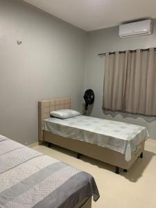 - une chambre avec 2 lits jumeaux et un ventilateur dans l'établissement Dunas residence casa 15- Lençois Maranhense, à Santo Amaro
