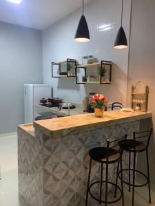 a kitchen with a counter with two bar stools at Dunas residence casa 15- Lençois Maranhense in Santo Amaro