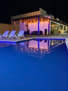 - une piscine avec 2 chaises et une maison dans l'établissement Dunas residence casa 15- Lençois Maranhense, à Santo Amaro