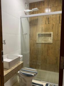 y baño con ducha, aseo y lavamanos. en Dunas residence casa 15- Lençois Maranhense, en Santo Amaro