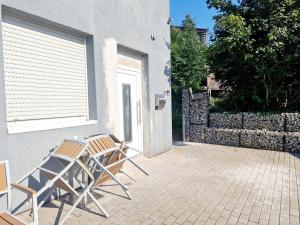 two chairs sitting on a patio next to a building at iBO-APART Ganze Ferienwohnung in Herzogenaurach in Herzogenaurach