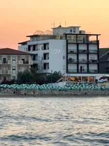 um hotel na praia com guarda-sóis e água em Hotel Costa Verde em Pineto