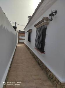 a hallway of a white building with a walkway at Casa La Alquería in Chiclana de la Frontera