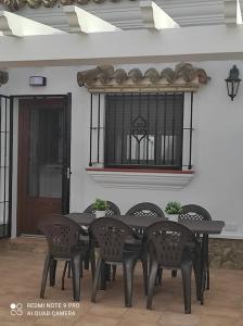 a black table and chairs in front of a building at Casa La Alquería in Chiclana de la Frontera