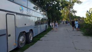 een groep mensen die over een stoep naast een bus loopt bij Kapsuły Sypialne AutokarSingliPL, Par, ciekawe miejsce in Władysławowo