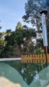 a pool of water with a fence and trees at RAMAL LODGE CONSTITUCION in Constitución