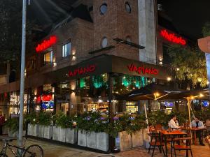 um restaurante com mesas e guarda-sóis à noite em LoftVista Cabrera 85 em Bogotá