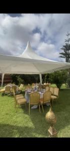 a table and chairs under a white tent at Gîte Jnane fès in El Jadida