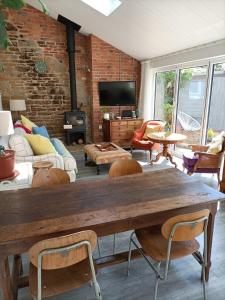 uma sala de estar com uma grande mesa de madeira e cadeiras em Cybil's Retreat - Renovated 2 bedroom house with enclosed garden em Uppingham