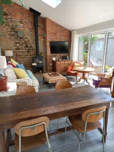a living room with a large wooden table and chairs at Cybil's Retreat - Renovated 2 bedroom house with enclosed garden in Uppingham