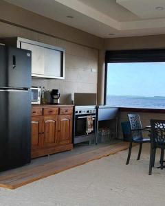 uma cozinha com um frigorífico e uma mesa com cadeiras em Le Village de Vairao em Vairao
