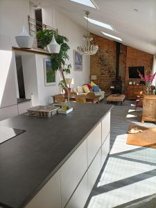 cocina con encimera negra y sala de estar. en Cybil's Retreat - Renovated 2 bedroom house with enclosed garden, en Uppingham