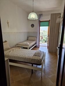 Cette chambre comprend deux lits et une fenêtre avec une traverse. dans l'établissement Appartamento D'Orazio, à Sorrente